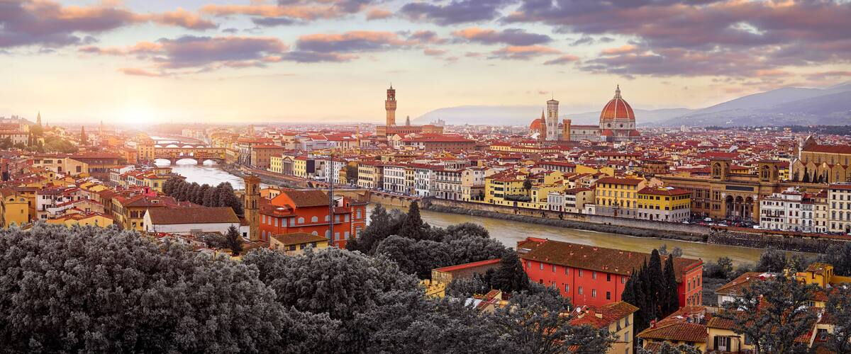 A panoramic view of a city with a prominent river, historic buildings, and a large dome structure.