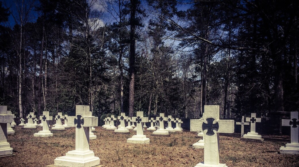 Final resting place for Brother Joseph, who created the art that is known as Ave Maria Grotto.This is a cemetery of only monks in residence at St. Bernard Abbey.
Ave Maria Grotto, in Cullman, Alabama, is a landscaped, 4-acre park in an old quarry on the grounds of St. Bernard Abbey, providing a garden setting for 125 miniature reproductions of some of the most famous religious structures of the world. It was added to the Alabama Register of Landmarks and Heritage on February 24, 1976, and to the National Register of Historic Places on January 19, 1984.
The stone and concrete models are the work of Brother Joseph Zoettl, a Benedictine monk of St. Bernard's Abbey, who devoted some 50 years to the project, the last three decades (1932 to 1961) almost without interruption. They incorporate discarded building supplies, bricks, marbles, tiles, pipes, sea shells, marbles, plastic animals, costume jewellery, toilet bowl floats and cold cream jars.
Born in 1878 in the Kingdom of Bavaria, Brother Joseph was maimed in an accident that left him slightly hunched due to cervical kyphosis. He immigrated to the United States as a teenager, settling in northern Alabama. Soon afterward he began studying at the newly founded Benedictine monastery of St. Bernard, where he took his vows in 1897. Br. Joseph was not allowed to be ordained as a priest, due to the rule of the period that stated any man with a distracting disability could not be ordained a priest. He ran the monastery’s power plant and was, even by a monk's standards, a withdrawn, quiet man. Brother Joseph rarely left Alabama, where he died in 1961.