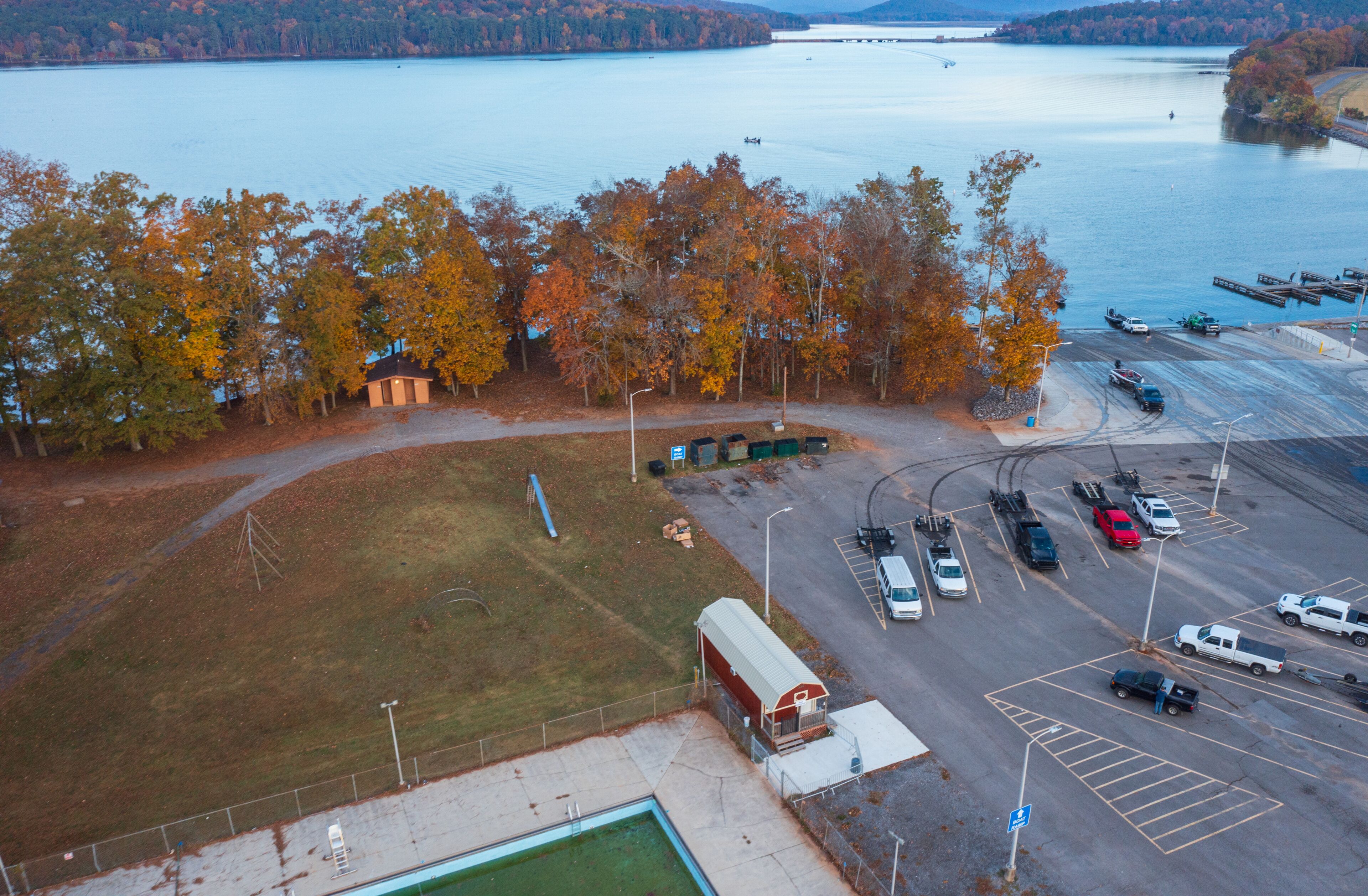 Aerial view of a bass tournament starting at a boat ramp marina in Scottsboro Alabama with boats on Guntersville Lake fishing on a colorful autumn day.