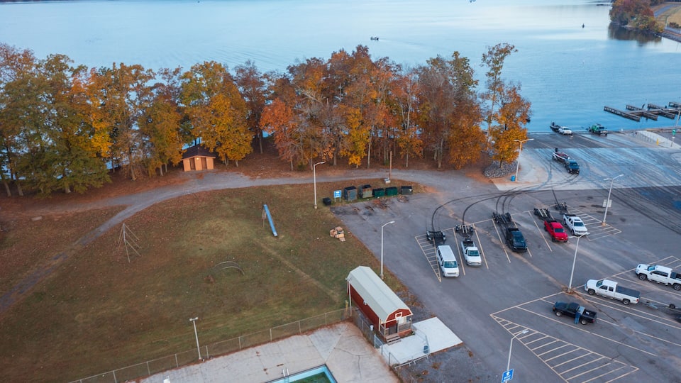 Aerial view of a bass tournament starting at a boat ramp marina in Scottsboro Alabama with boats on Guntersville Lake fishing on a colorful autumn day.