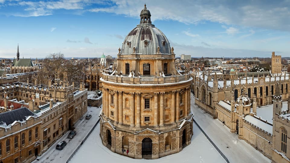 A historic building with a prominent dome, surrounded by snow-covered architecture.