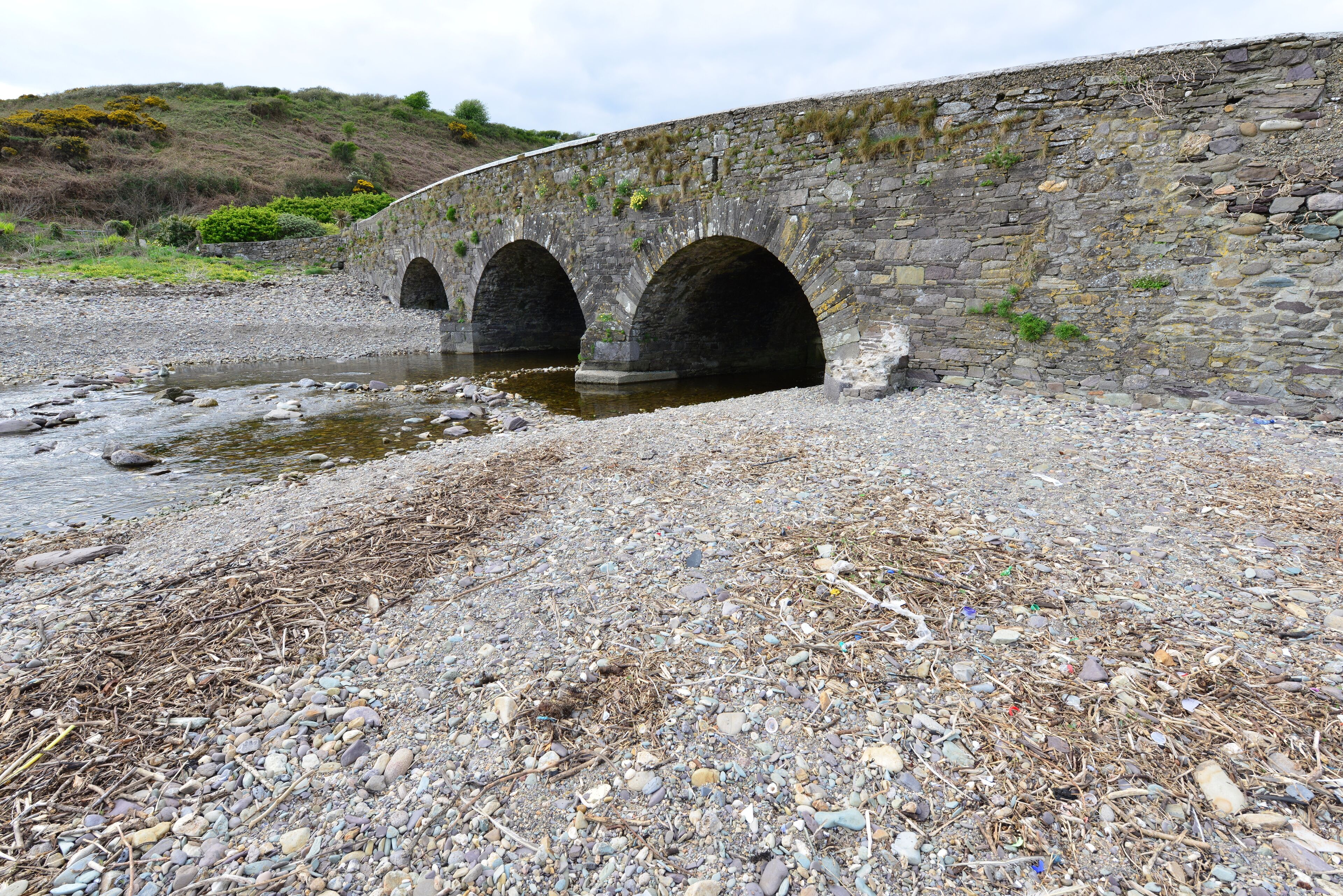 A stone bridge over a rocky stream.
