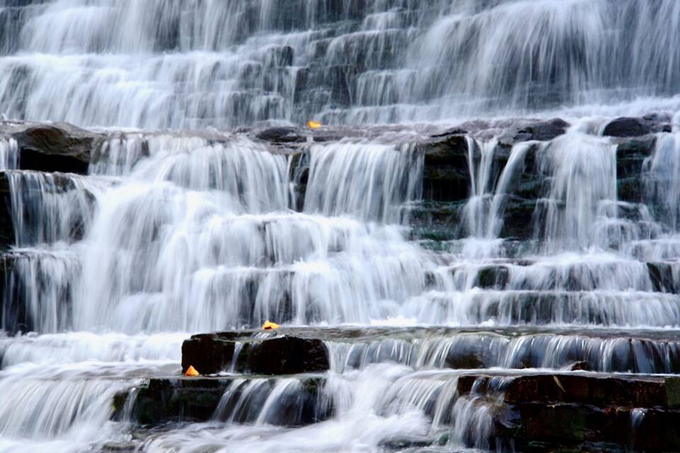 Una cascada en terrasses que flueix sobre roques.