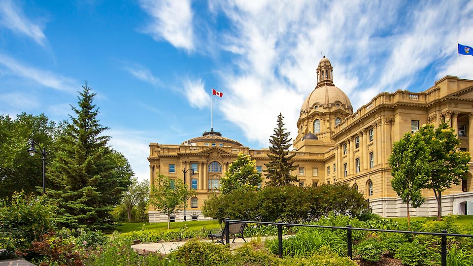 A large, historic building with a dome and columns, surrounded by lush greenery and trees.