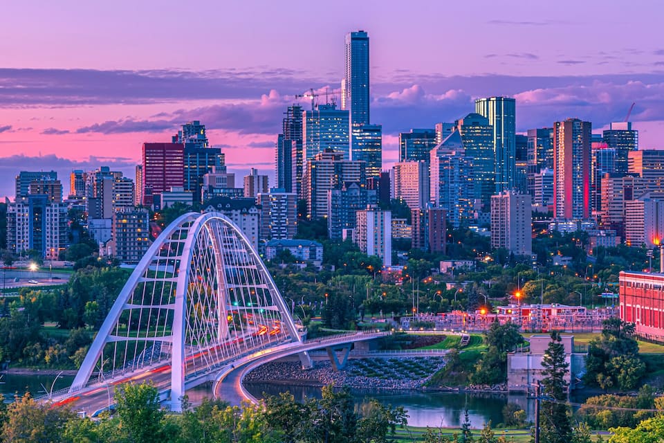 Un paysage urbain avec une grande roue bien visible, des gratte-ciel modernes et une rivière.