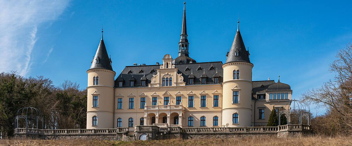 A large, historic building with multiple towers and a prominent steeple.