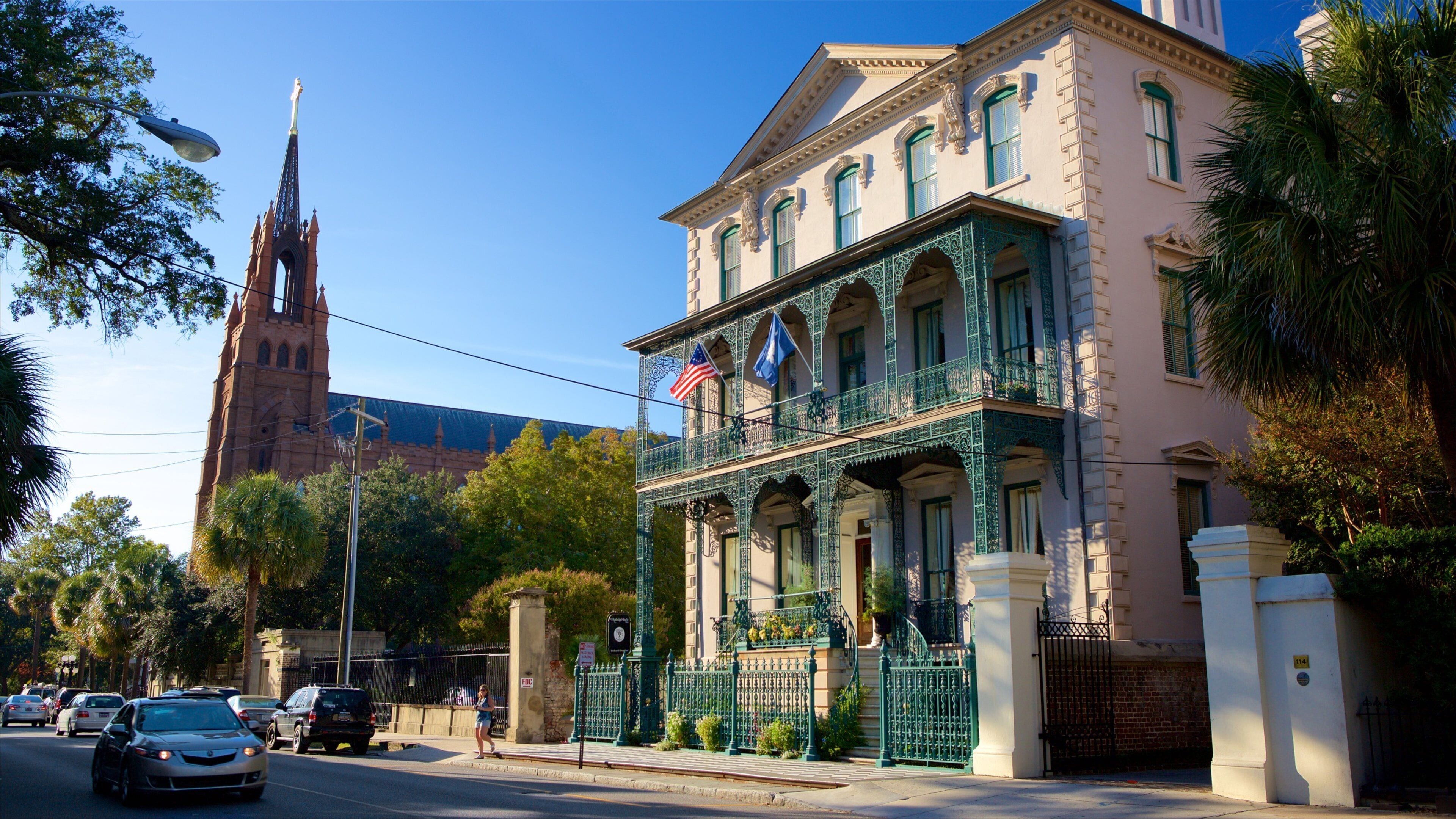 A historic building with ornate balconies and a church steeple in the background.