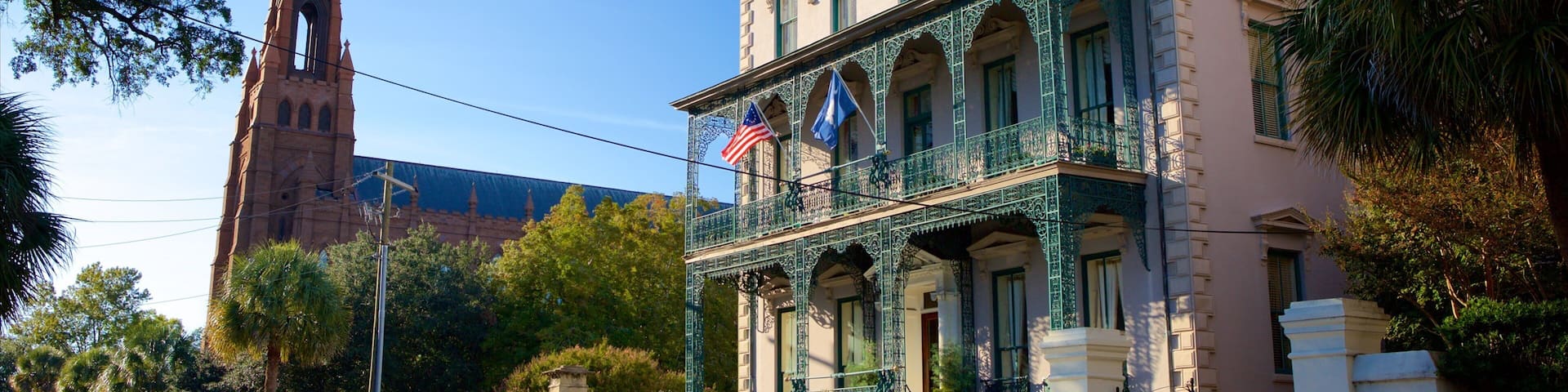 A historic building with ornate balconies and a church steeple in the background.