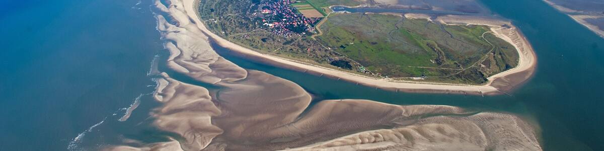 An aerial view of a coastal landscape with a large island, sandy beaches, and a network of waterways.