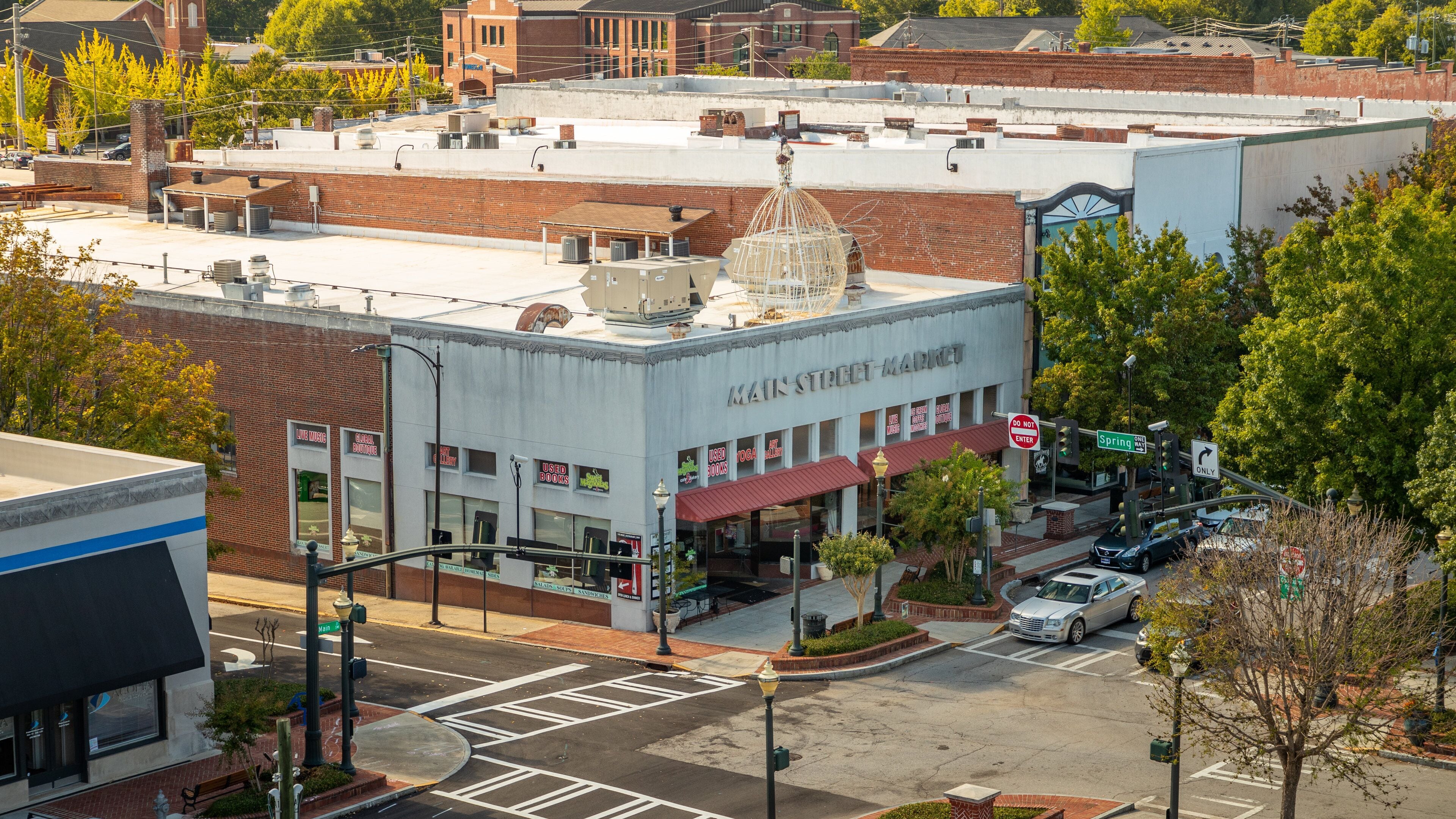 Main Street Market building with a dome on top, surrounded by trees and other buildings.