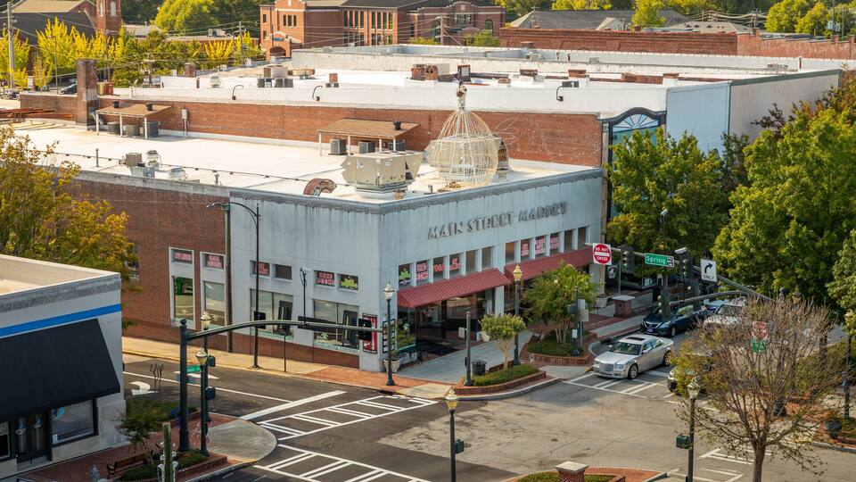 Main Street Market building with a dome on top, surrounded by trees and other buildings.