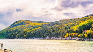 Autumn Fall nature landscape mountains banner background in Quebec, Canada. St Lawrence river in Charlevoix region, North America. Tourist person with arms up open in freedom happy of travel holidays.