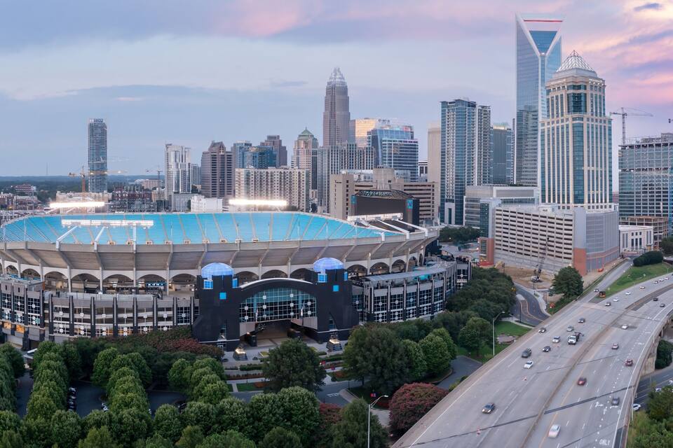 A city skyline with a large stadium and modern skyscrapers.