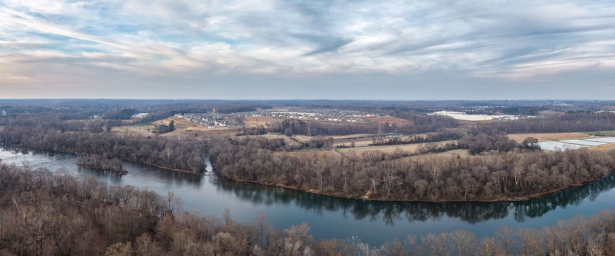 A river winding through a town with buildings and trees.