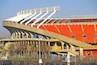 Ein Stadion mit roten Sitzen und einer gewölbten Dachkonstruktion.
