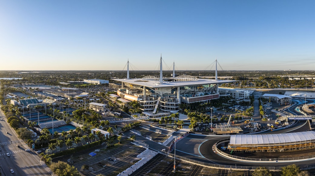 Miami Gardens, USA - 23 February 2026: Aerial view of Hard Rock Stadium bathed in the warm glow of the setting sun, juxtaposed against the sleek lines of the race track.