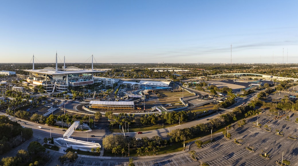 Miami Gardens, USA - 23 February 2026: Aerial view of Hard Rock Stadium bathed in the warm glow of a setting sun, its sleek architecture contrasting with the surrounding lush greenery.