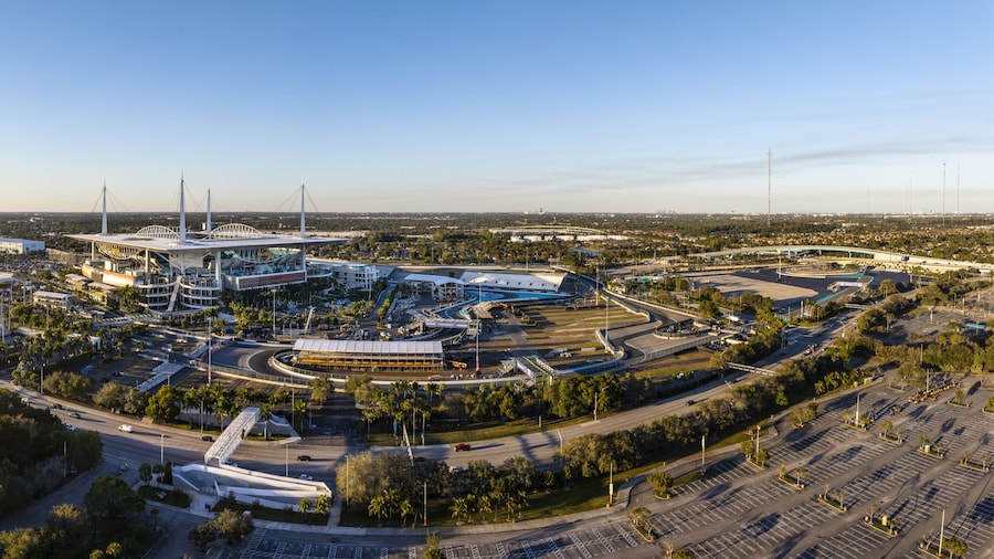 Miami Gardens, USA - 23 February 2026: Aerial view of Hard Rock Stadium bathed in the warm glow of a setting sun, its sleek architecture contrasting with the surrounding lush greenery.