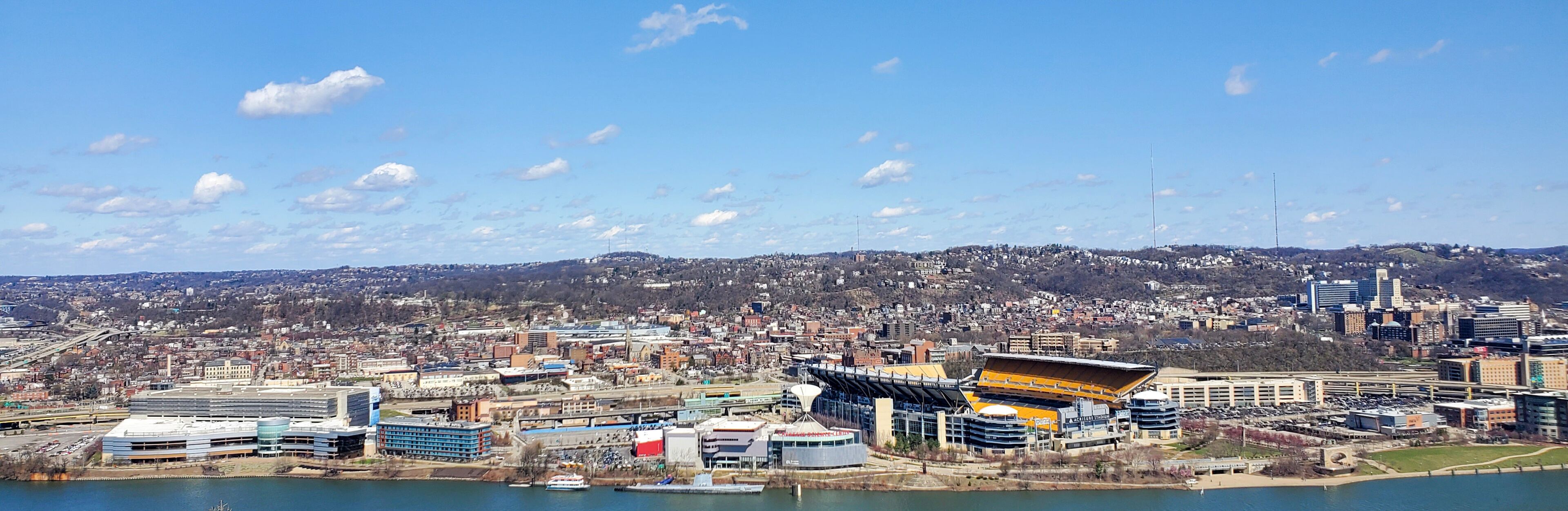 Pittsburgh, Pennsylvania, USA – April 10, 2024: Panoramic view of Point State Park where the Allegheny and Monongahela Rivers meet to form the Ohio River, with Acrisure Stadium and downtown in view.