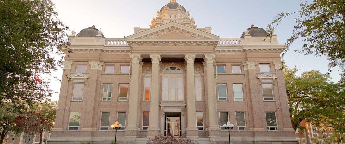 A large, historic building with a central dome and symmetrical facade.