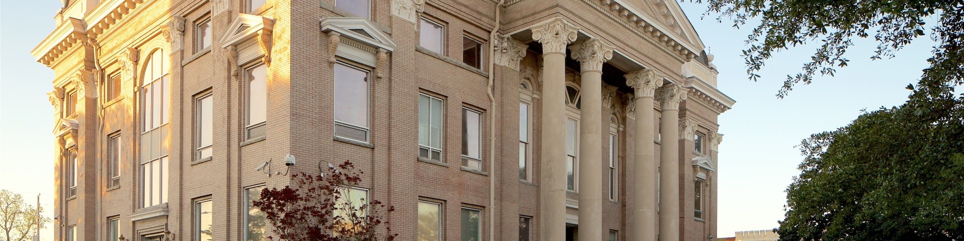 A large, historic building with classical architecture, featuring columns, large windows, and a symmetrical facade.