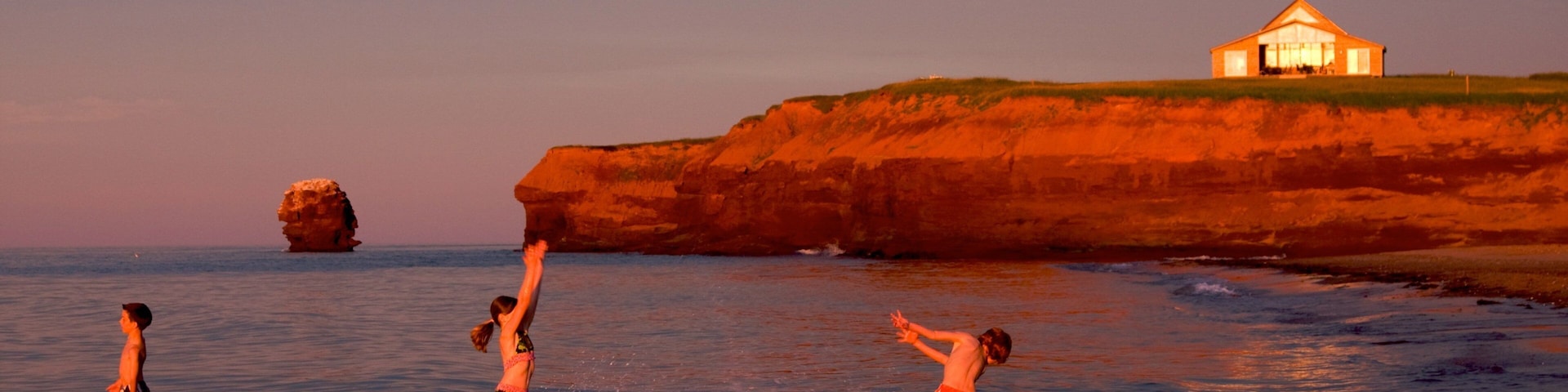 Prince Edward Island which includes swimming, rugged coastline and a sunset