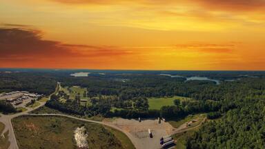 a stunning aerial panoramic shot of the blue waters of Lake Hartwell surrounded by vast miles of lush green trees and grass with powerful clouds at sunset in Fair Play South Carolina USA
