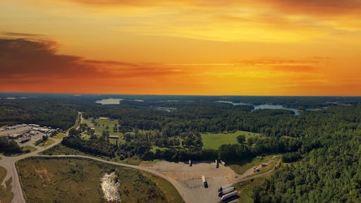 a stunning aerial panoramic shot of the blue waters of Lake Hartwell surrounded by vast miles of lush green trees and grass with powerful clouds at sunset in Fair Play South Carolina USA