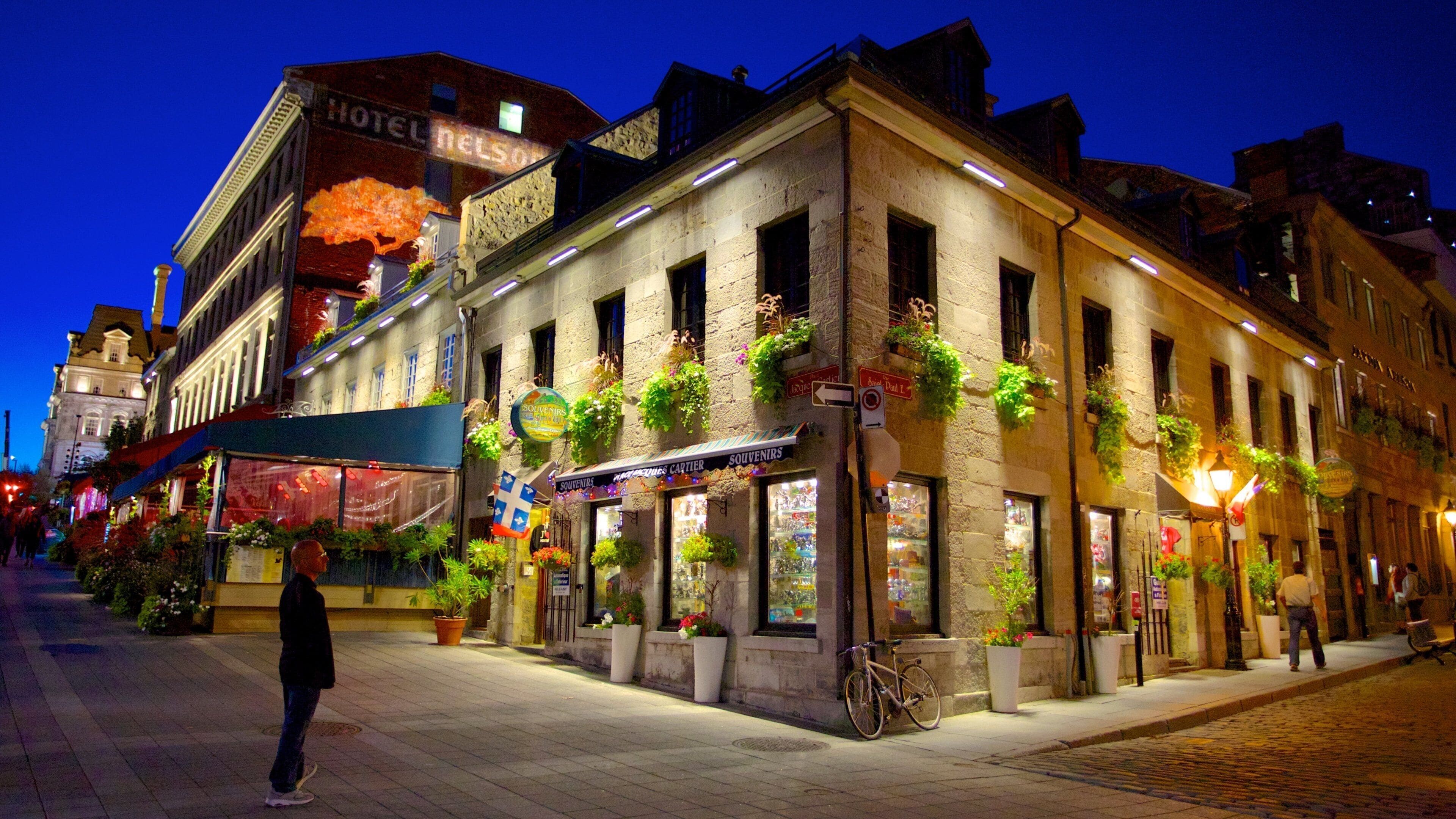 A historic building with a 'Hotel Nelson' sign, adorned with potted plants and flowers.