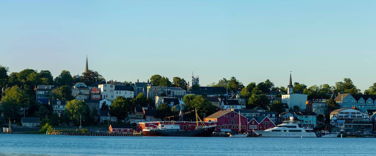 A harbor with boats, a church steeple, and houses along the waterfront.