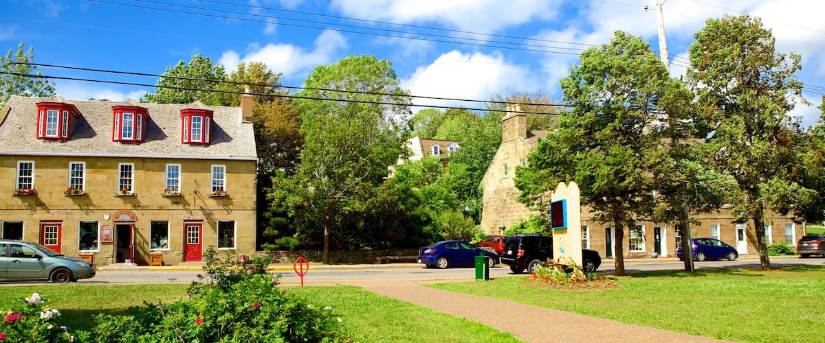 A quaint town with stone buildings, a church, and lush greenery.