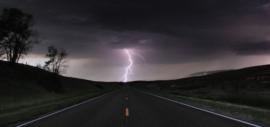 A single cloud-to-ground bolt lands at the end of a rural road, Lexington, Nebraska, USA