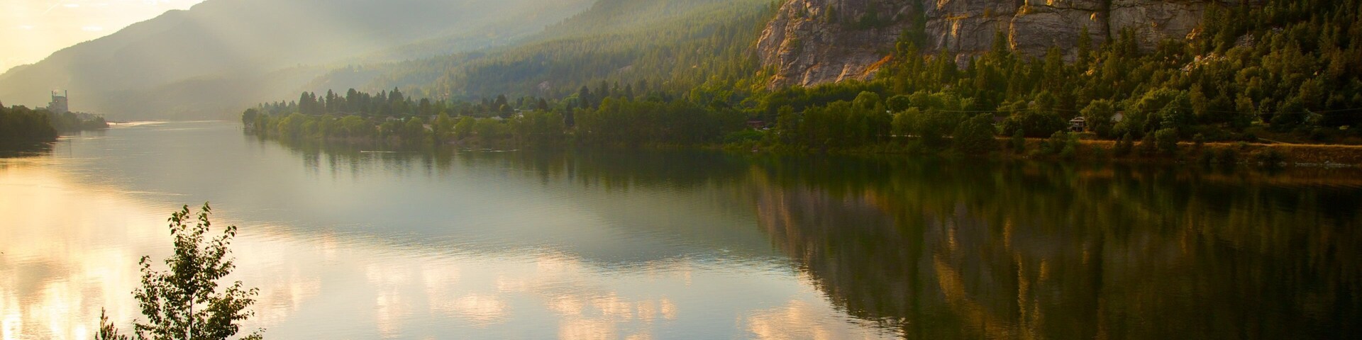 A calm lake surrounded by mountains and trees.