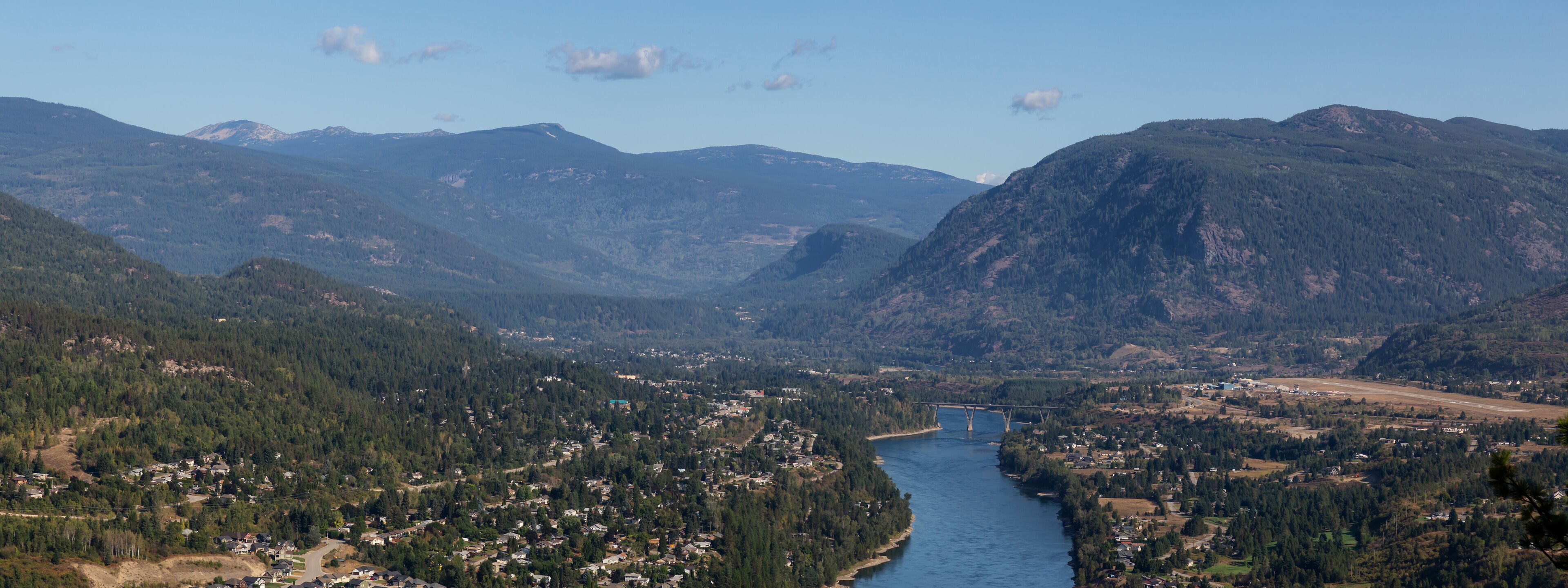 Aerial Panoramic View of a small town, Castlegar, during a sunny summer day. Located in Central Kootenay, British Columbia, Canada.