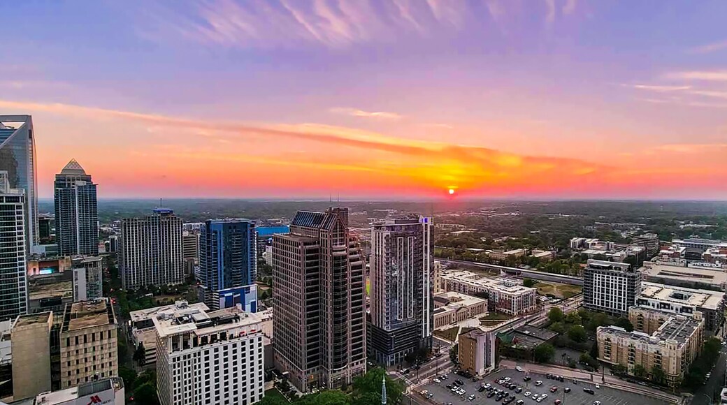 A cityscape at sunset with modern skyscrapers and a clear sky.