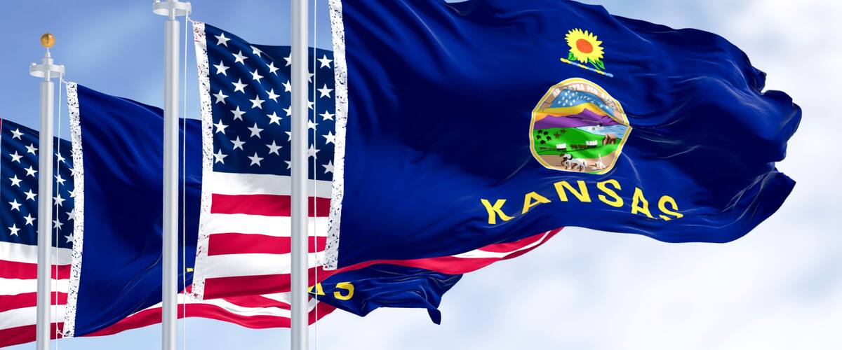 The Kansas state flag with the state emblem and the American flag.