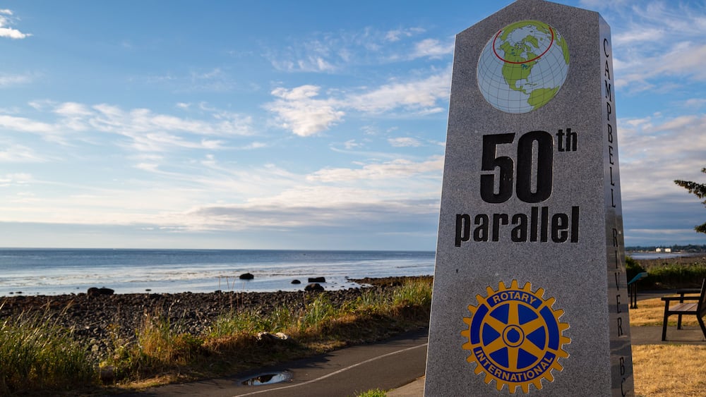 Ein aus Granit gefertigtes Denkmal mit der Inschrift „50. Parallel“ und dem Logo von Rotary International.