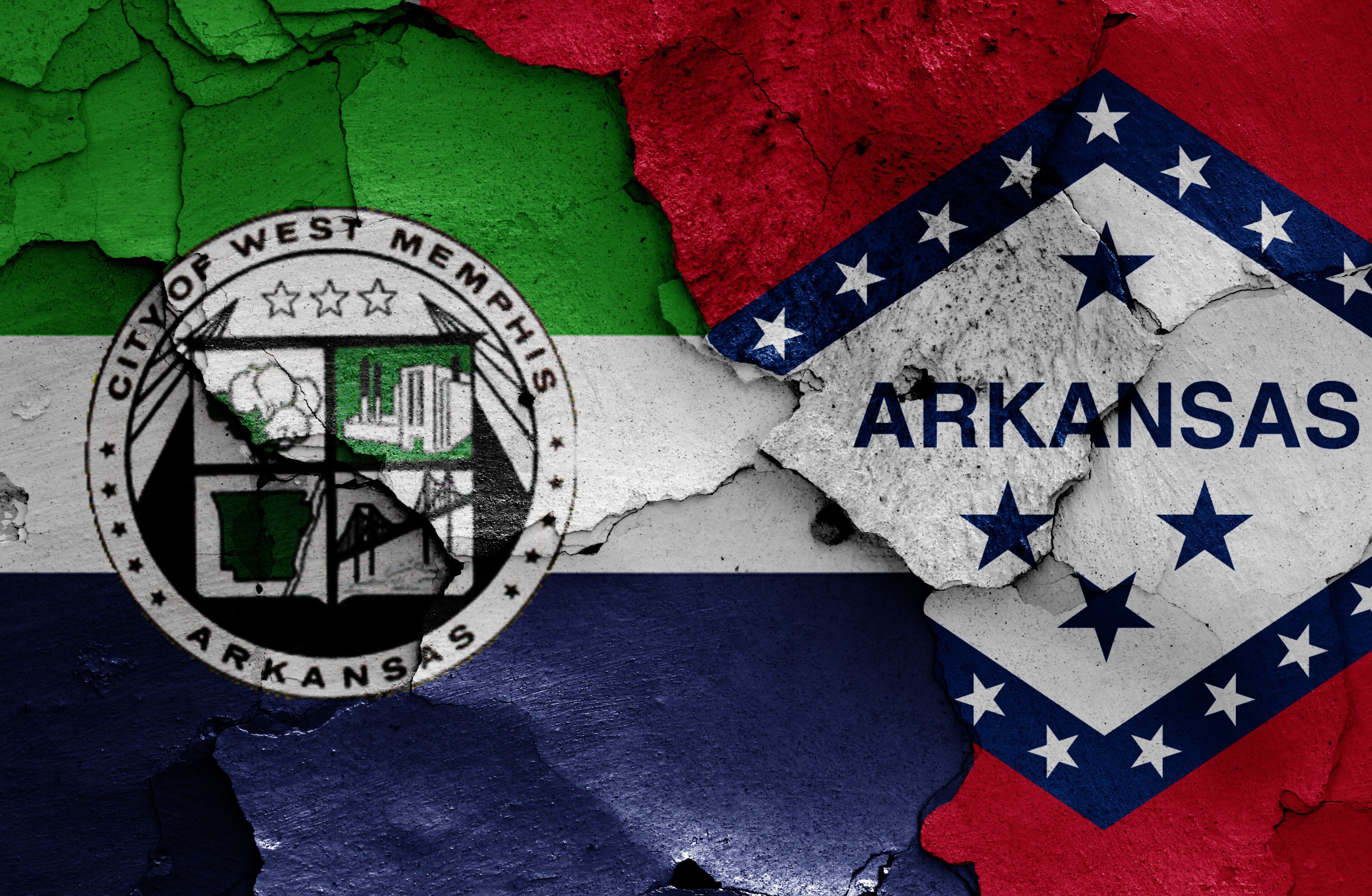 flags of West Memphis and Arkansas painted on cracked wall