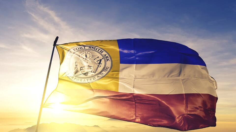 A flag with a blue, white, and yellow design, featuring a seal and the text "City of Fort Smith Arkansas 1822".