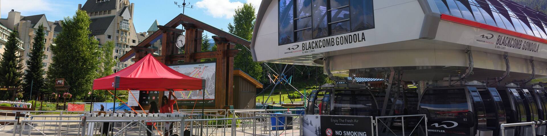 A gondola lift station with a red canopy and a sign for Blackcomb Gondola.