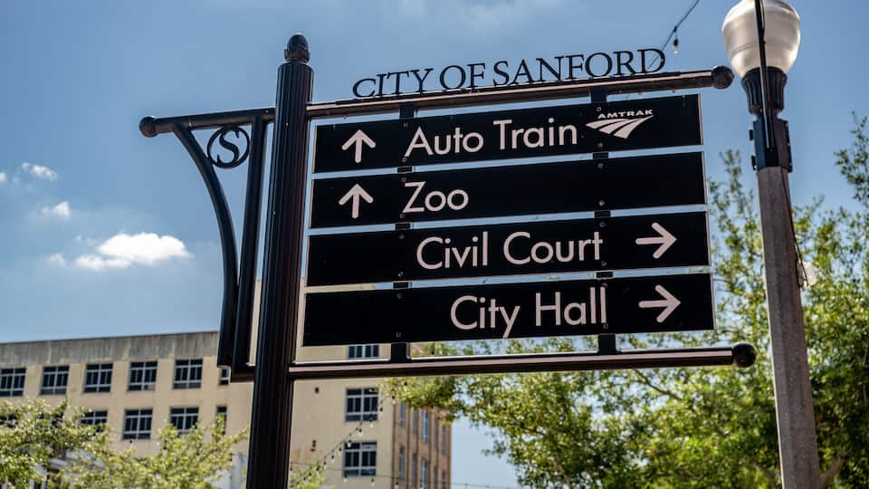 A directional sign for City of Sanford with arrows pointing to Auto Train, Zoo, Civil Court, and City Hall.