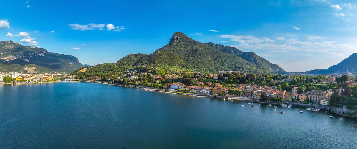 A coastal town with a prominent mountain, a calm bay, and a bridge connecting the town to the mainland.