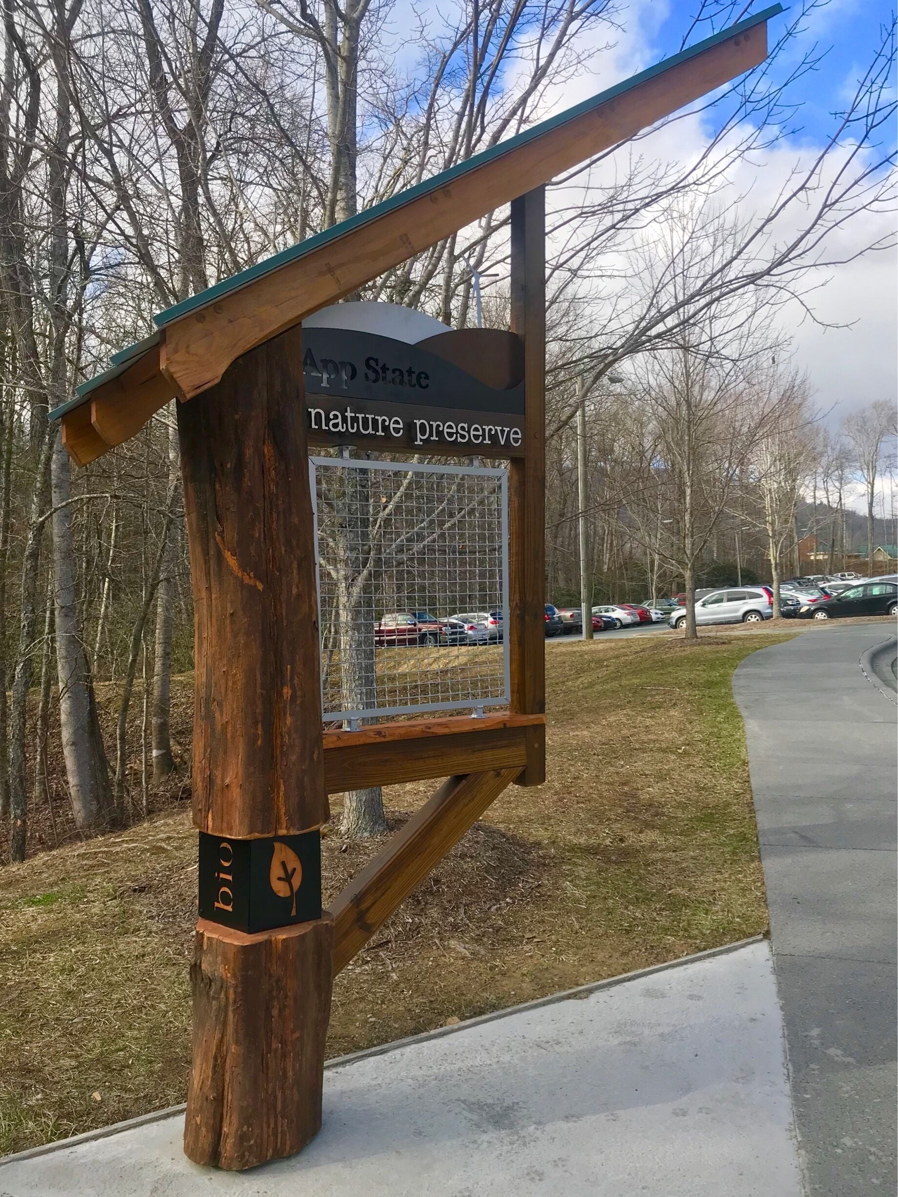 This photo seeks to question the extent to which Appalachian can be characterized as an untouched, natural landscape. The central focus of the image is a sign placed this year that reads “App State Nature Preserve.” The background of the photo puts the location of the sign in context by featuring the expansive parking lot it is placed next to. The “nature preserve” is in reality a very small expense of land, only a short concrete staircase away from a parking area for first and second year students. Like much of the Appalachian region, this natural landscape has been reduced to a token "nature preserve” next door to an asphalt jungle. #appalachianechoes  