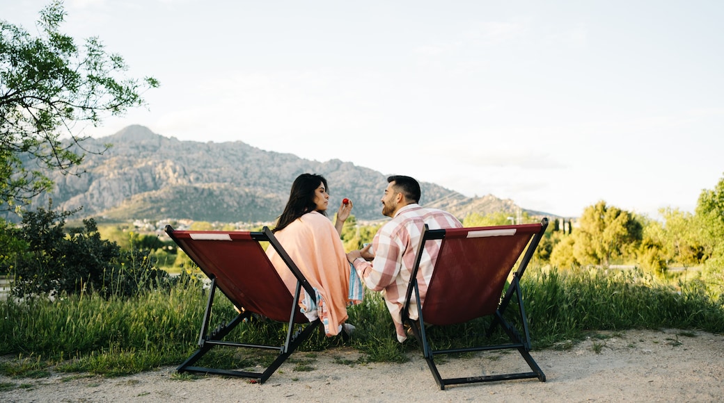 Traveling couple sitting in camping chairs in mountainous terrain