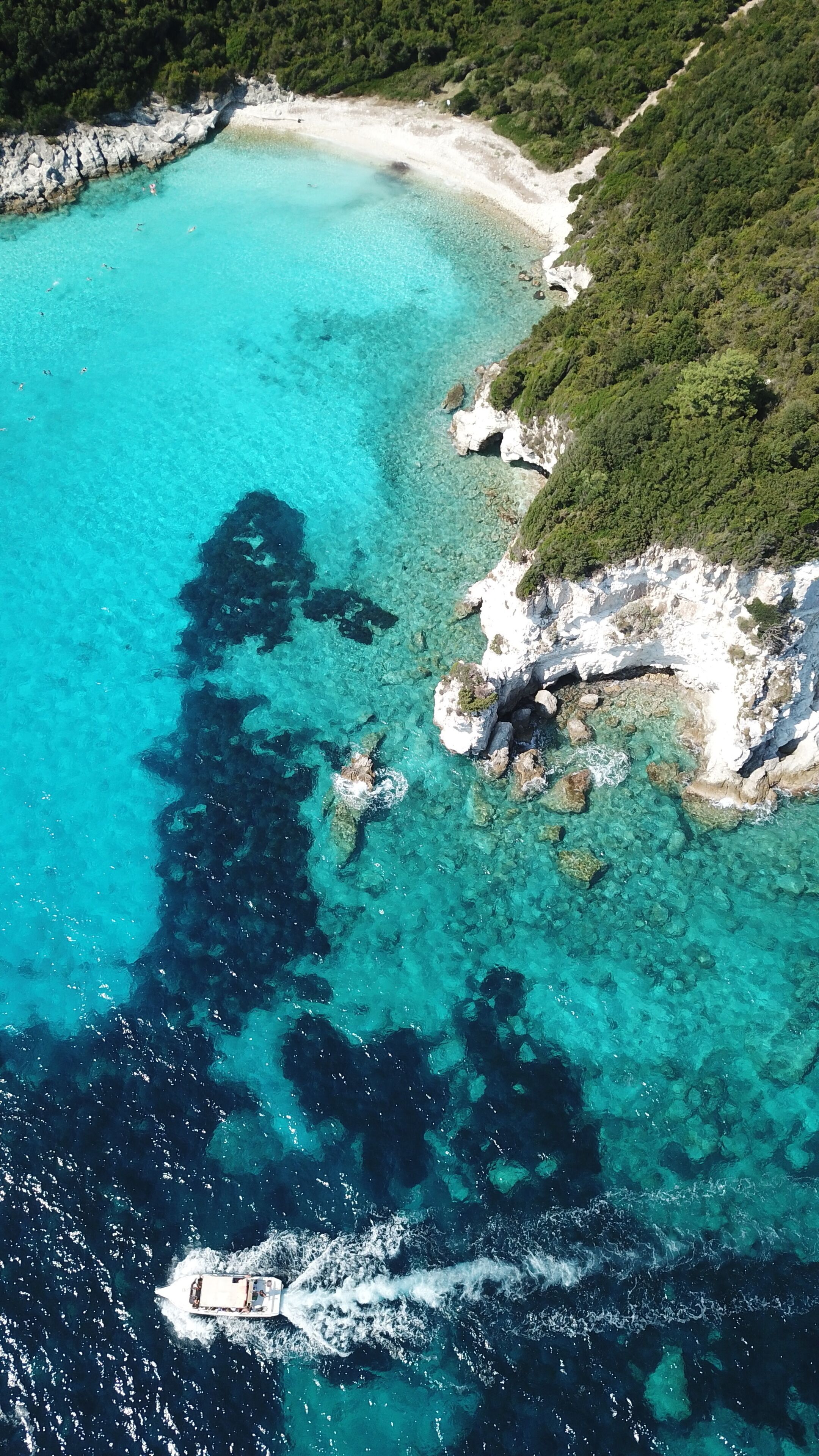 Aerial drone photo of tropical paradise turquoise beach of Voutoumi with sail boats docked in island of Antipaxos, Ionian, Greece