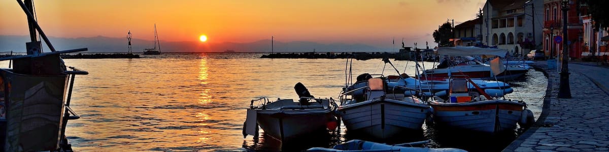 Un coucher de soleil sur un port tranquille, avec des bateaux amarrés le long de la rive.