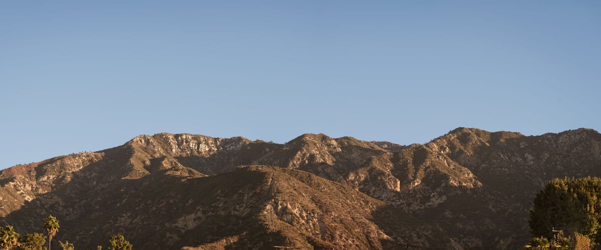 A mountain range with rugged terrain and sparse vegetation.