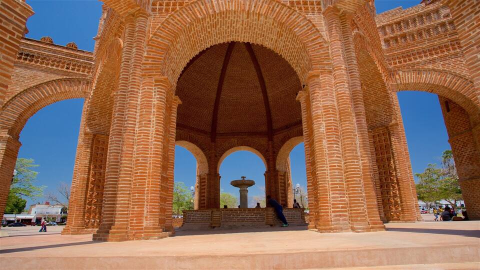 A large brick archway with a central fountain.