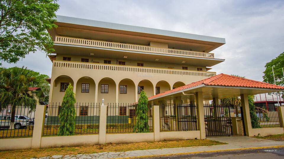 A multi-story building with a red-tiled roof and a covered entrance.