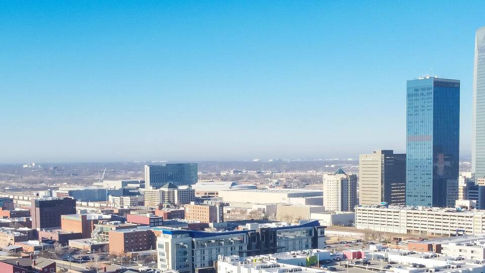 Panorama aerial view downtown Oklahoma City with apartment complex, office buildings, skyscraper business district, residential high-rise condo, urban street sunny clear blue sky winter time
